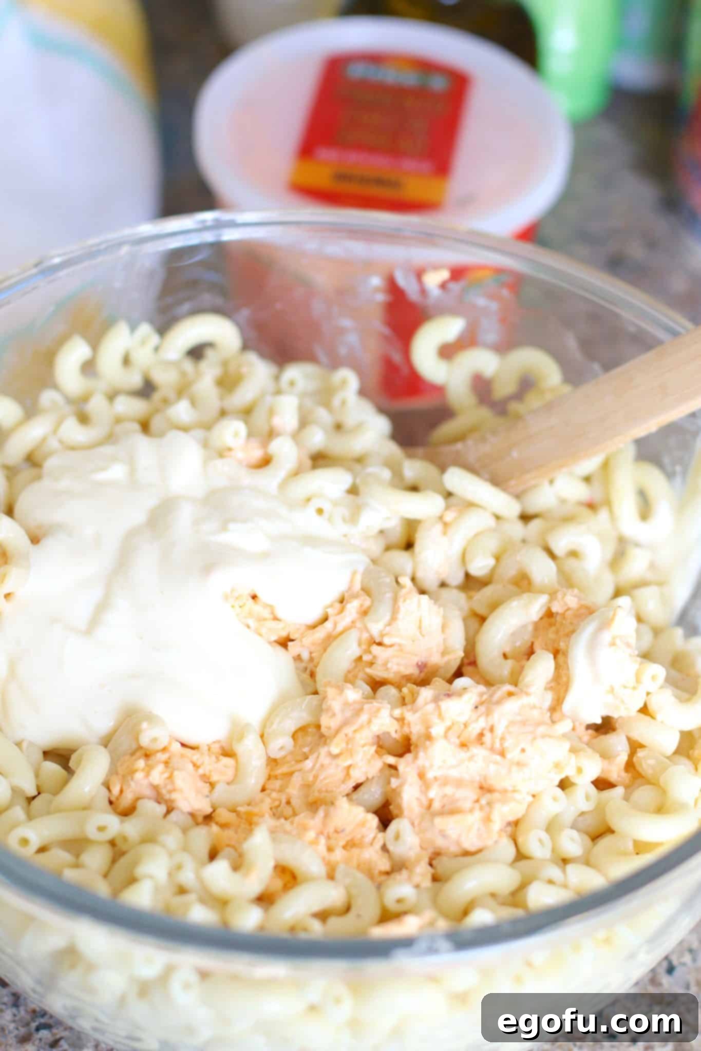 Homestyle Pimiento Macaroni Salad 7 pimiento cheese, mayonnaise, macaroni noodles mixed in a bowl.