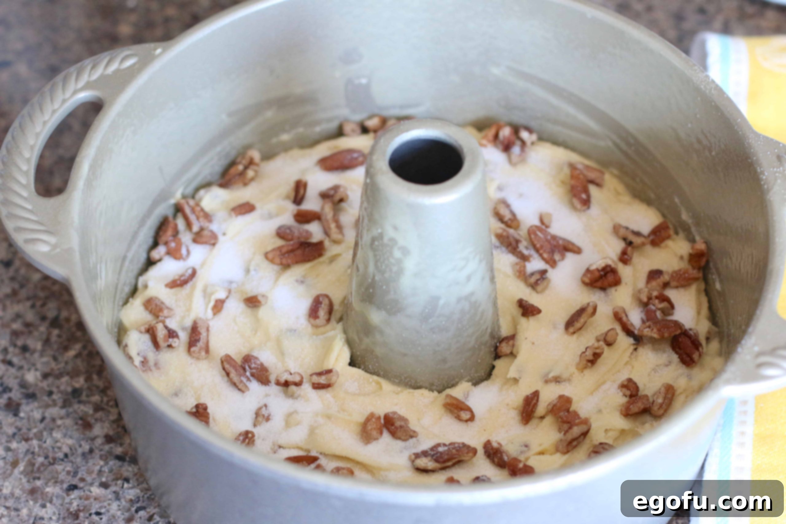 Heirloom Southern Pecan Pound Cake 12 Homemade pecan pound cake batter, smoothed into a bundt pan and generously sprinkled with additional chopped pecans and a touch of sugar before baking.