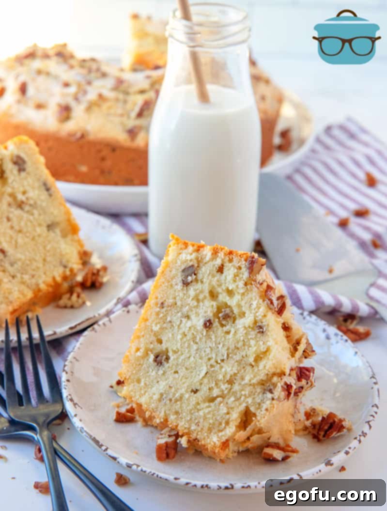 Heirloom Southern Pecan Pound Cake 13 A perfectly baked slice of Southern Pecan Pound Cake, ready to be enjoyed, presented on a white plate with a rustic milk bottle in the soft-focus background.