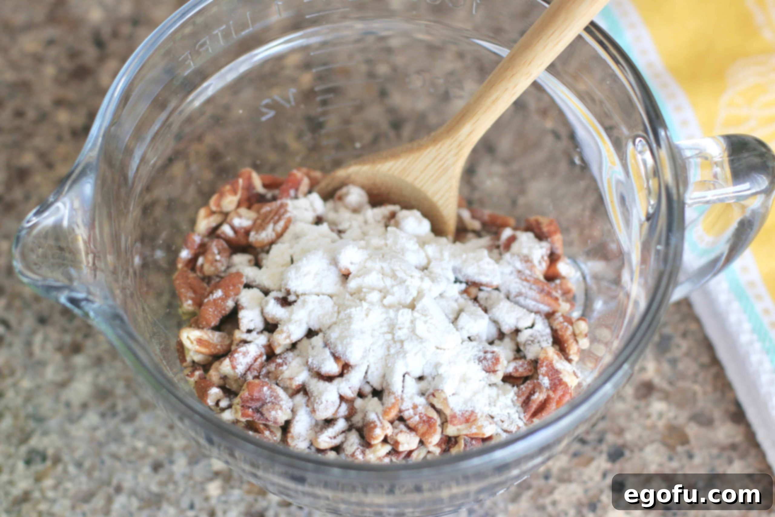 Heirloom Southern Pecan Pound Cake 6 A small bowl containing chopped pecans thoroughly mixed with a tablespoon of flour, prepared to be folded into the cake batter.