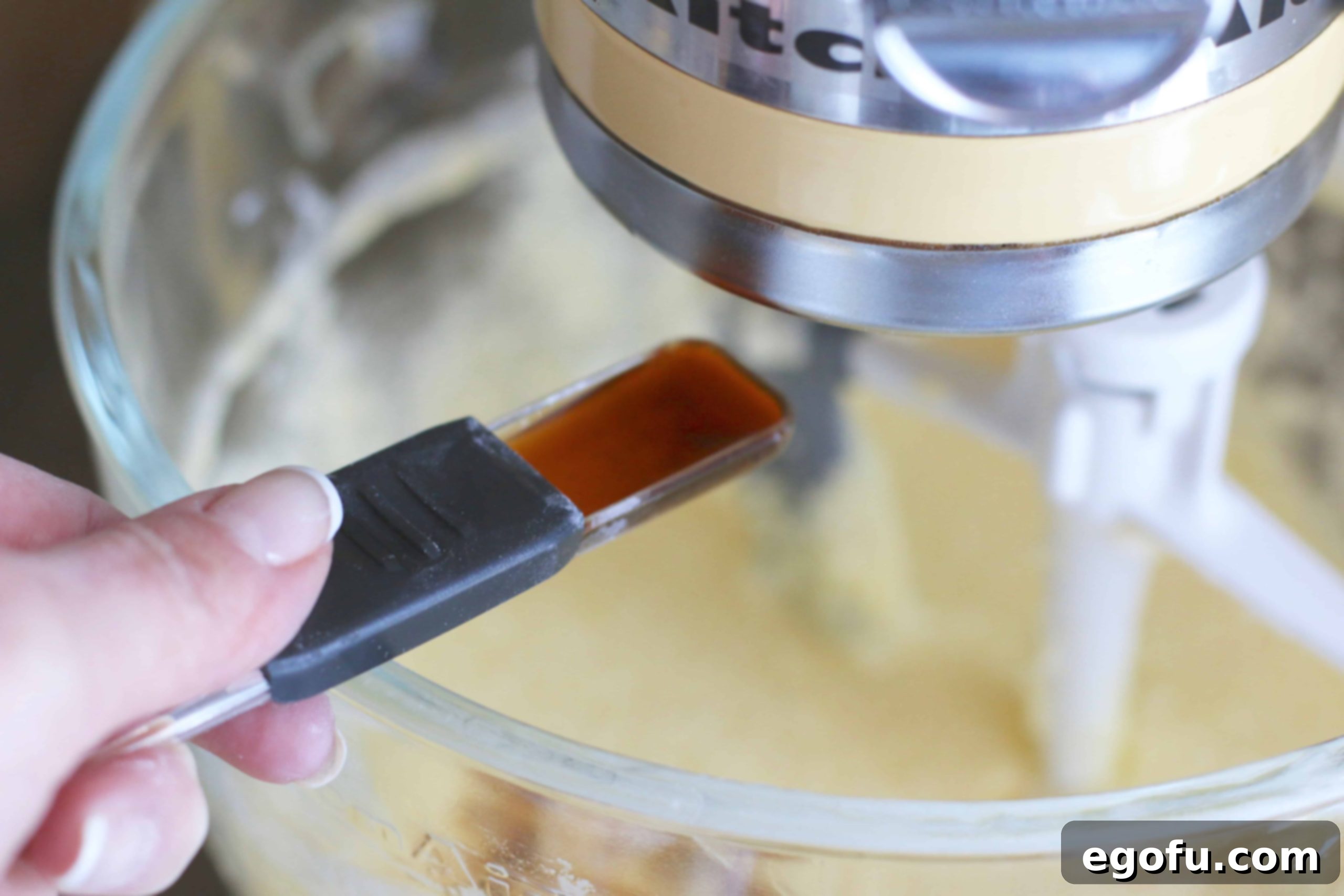 Heirloom Southern Pecan Pound Cake 9 Pure vanilla extract being added to the creamy butter, sugar, and egg mixture in a mixing bowl, enriching the pound cake batter with aromatic flavor.