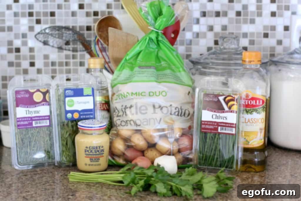 A selection of ingredients for French Potato Salad: little potatoes, Dijon mustard, and fresh herbs.