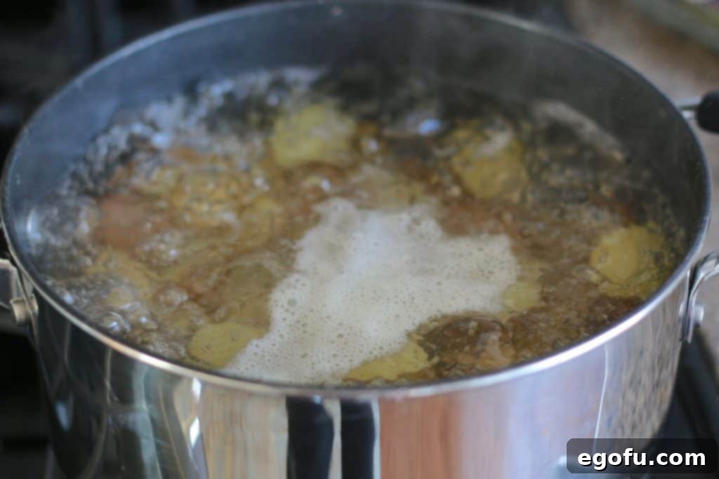 Potatoes boiling in salted water, cooked until fork-tender for French Potato Salad.