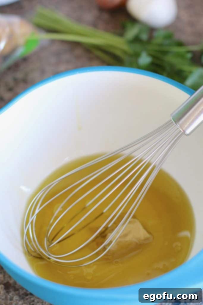 Ingredients for the vinaigrette base – olive oil, white wine vinegar, and Dijon mustard – in a mixing bowl.