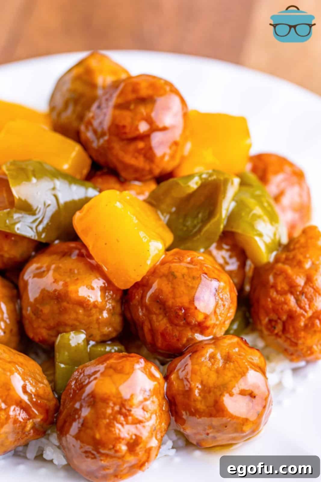 Sticky Sweet & Sour Crockpot Meatballs 12 Closeup photo of sweet and sour meatballs on white rice.