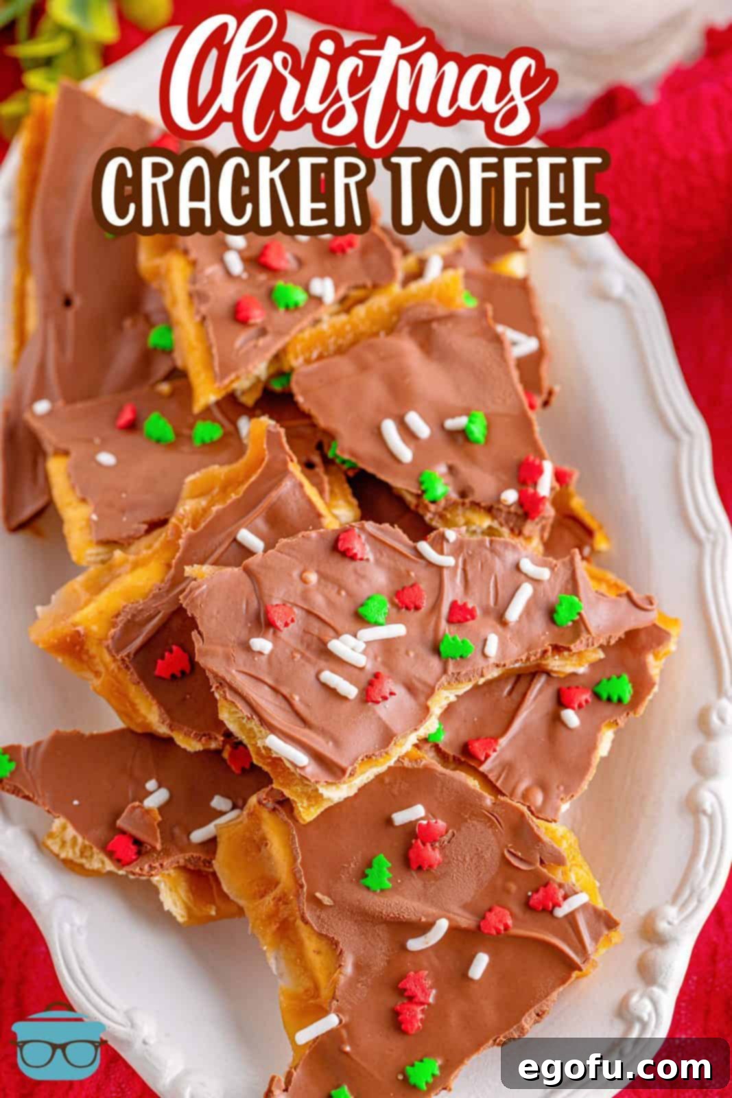 Christmas Caramel Cracker Crunch 3 a stack of cracker toffee on a white platter with a red background.
