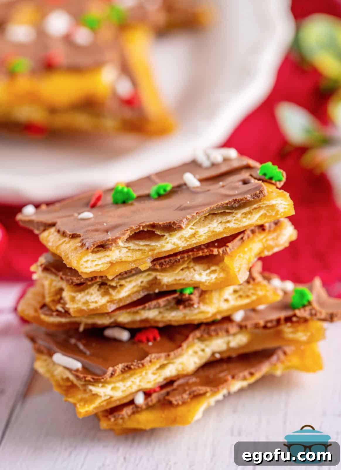 Christmas Caramel Cracker Crunch 9 a tall stack of Christmas Crack on a white wood surface.