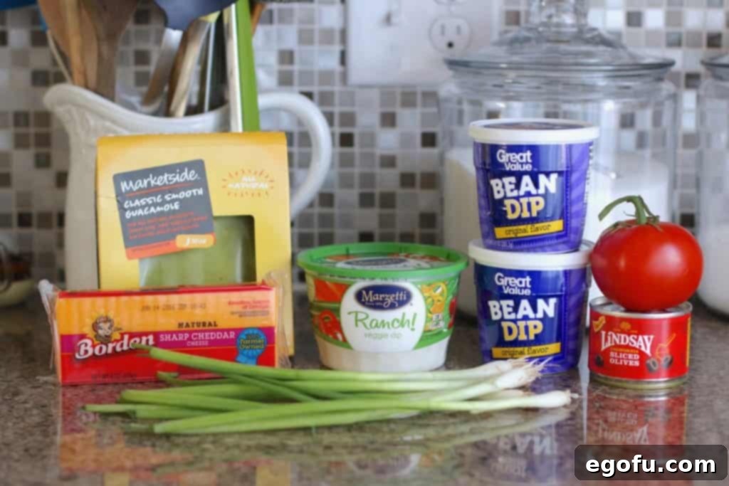 recipe ingredients been dip, ranch dip, guacamole, cheese, green onion, tomatoes, olives