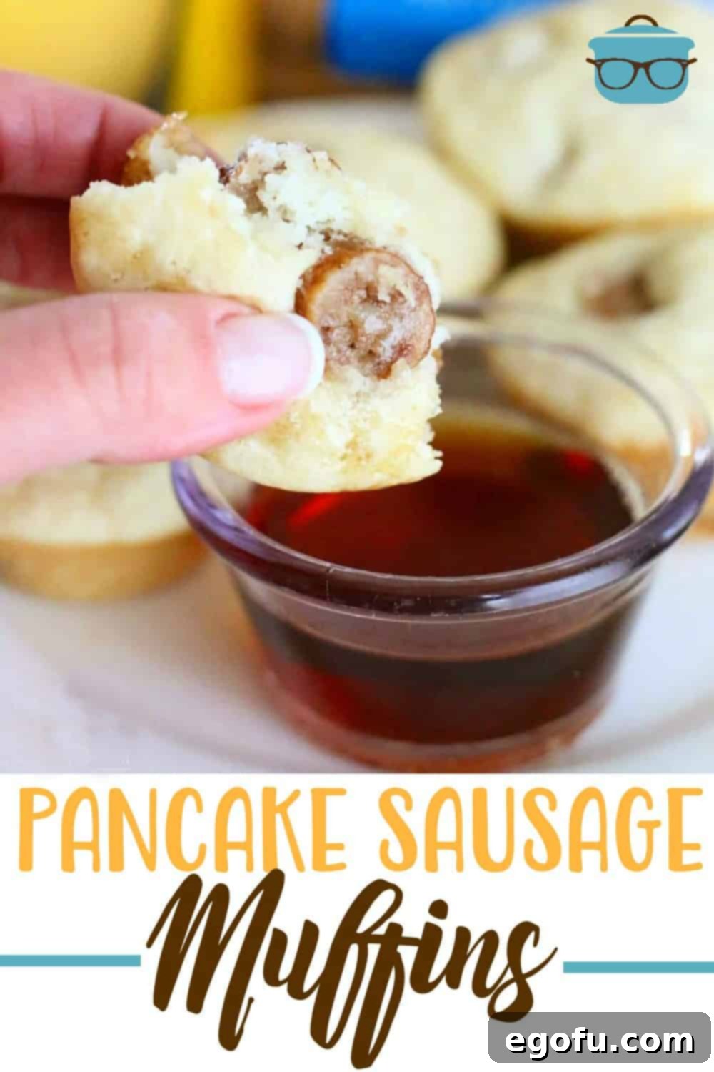 A hand holds up a partially eaten pancake sausage muffin over a small bowl of maple syrup, highlighting the delicious combination.