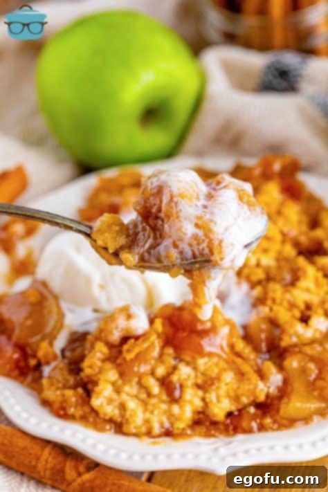 A spoon holding a bite of Crock Pot Apple Dump Cake.