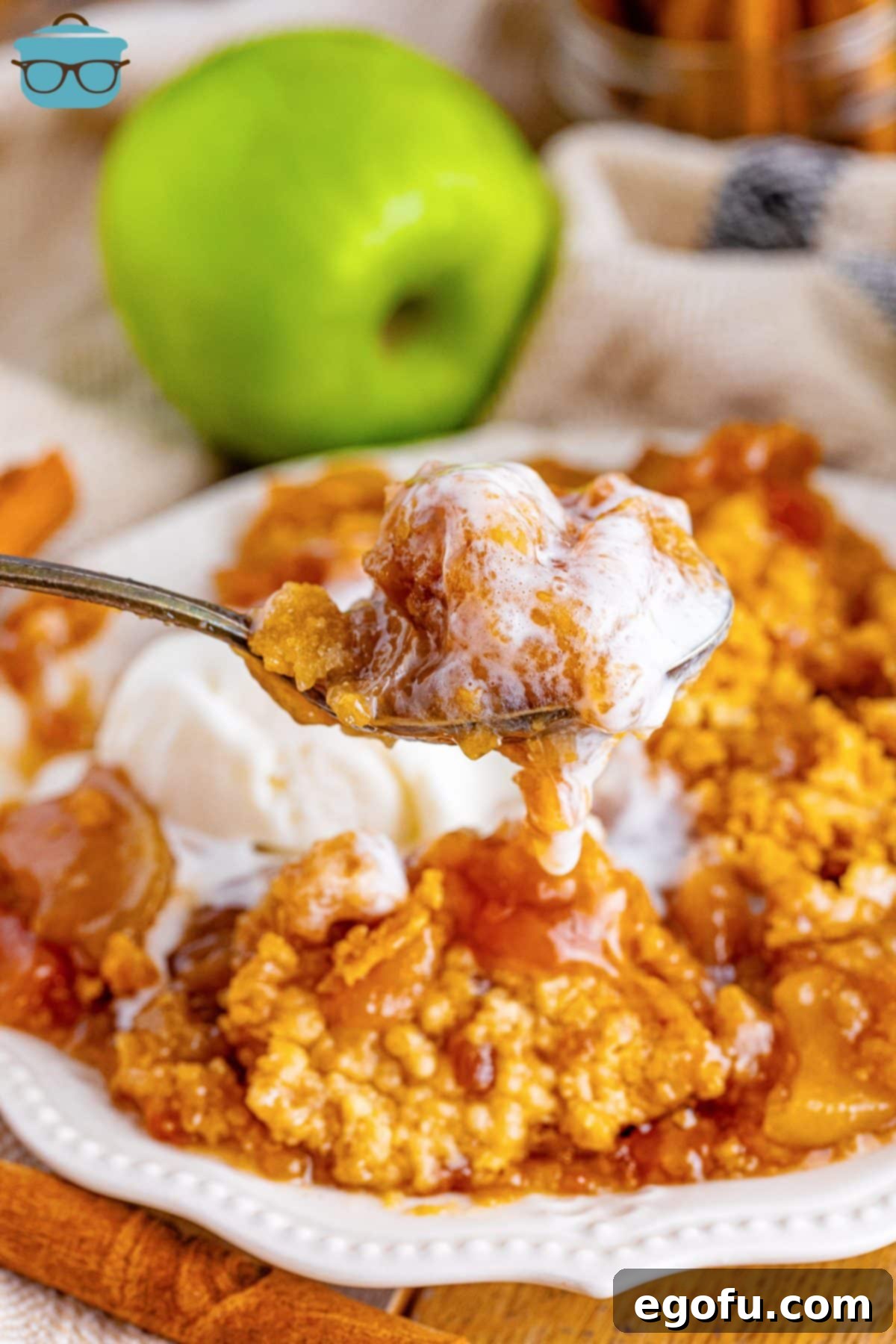 A spoon holding a bite of Crock Pot Apple Dump Cake.