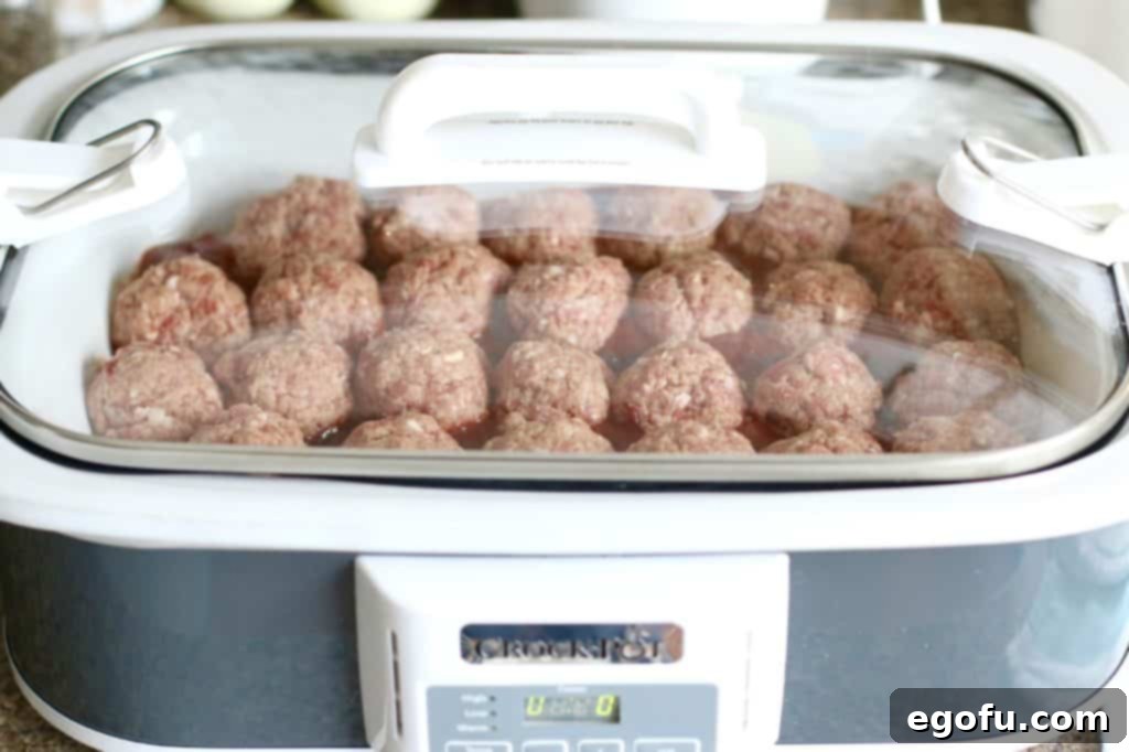 covered homemade meatballs in a slow cooker sauce with lid on