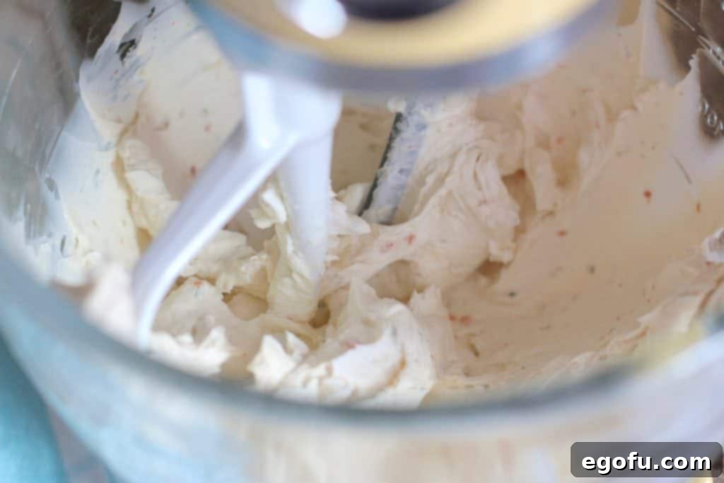 The Great Pumpkin Cheese Ball 7 vegetable cream cheese mixed with regular cream cheese in a stand mixer.