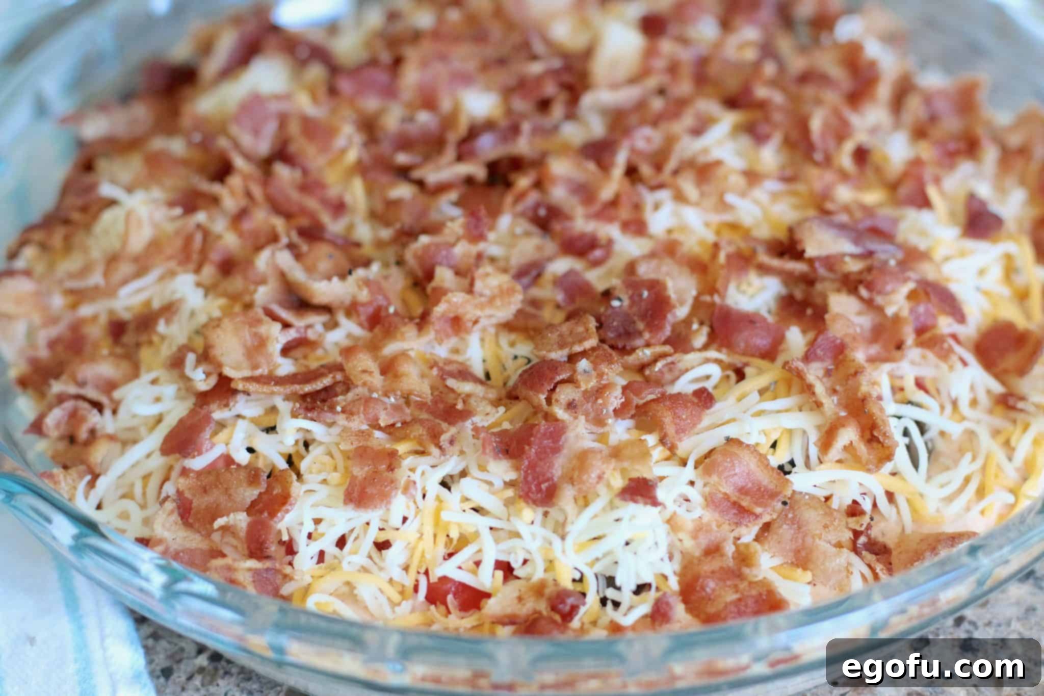 Hot Cheesy Bacon Dip 8 Crumbled bacon perfectly topping a creamy, cheesy dip mixture, ready for baking or serving cold.