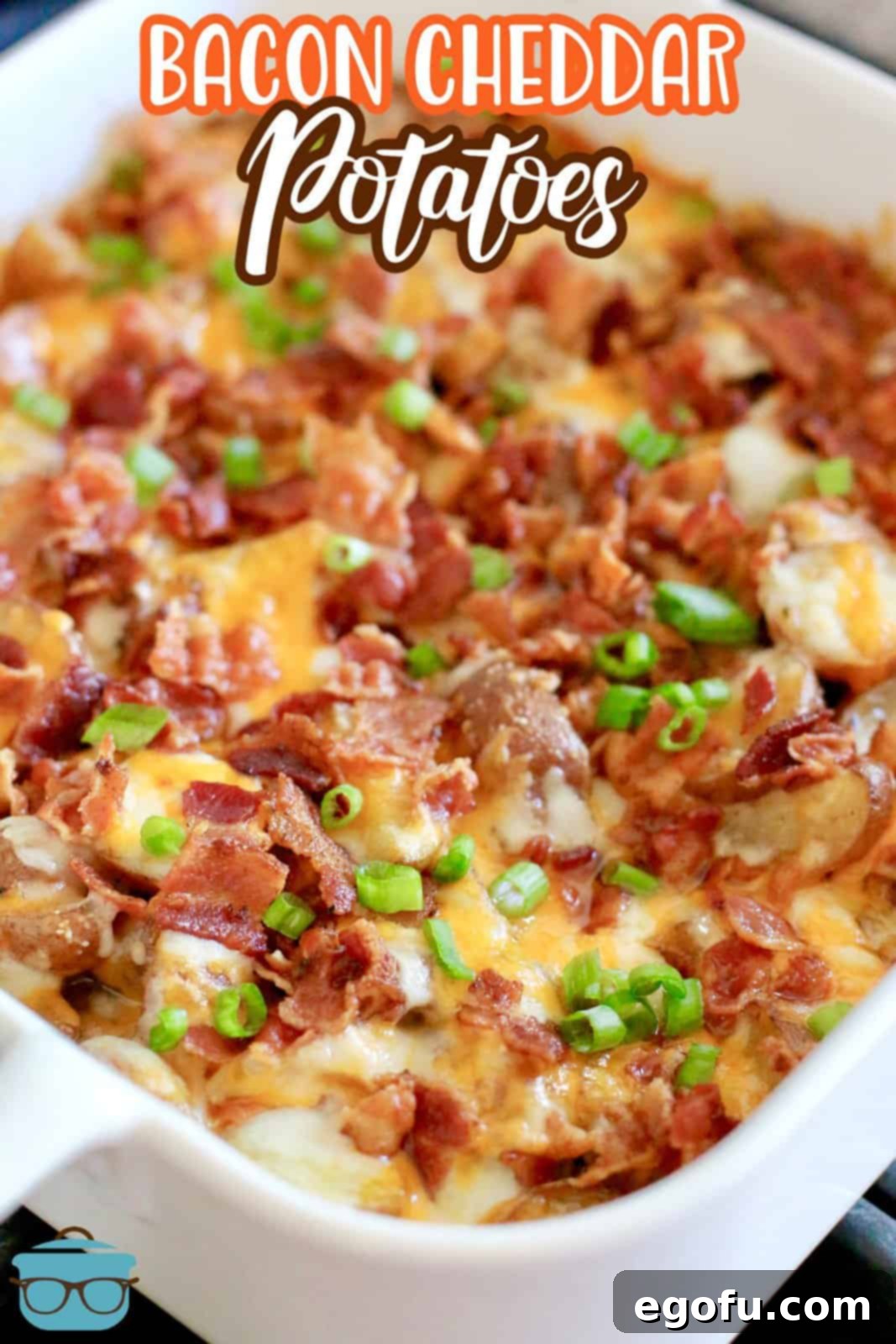 Fully cooked baby potatoes in a white square baking dish topped with melted cheese and cooked bacon.