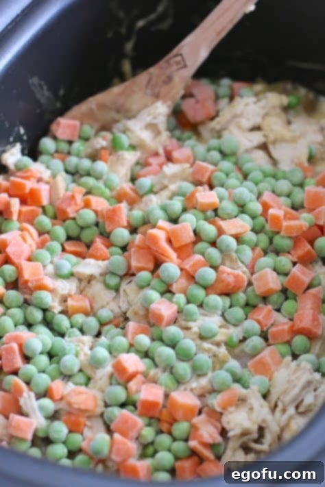 frozen peas and carrots added into crock pot.