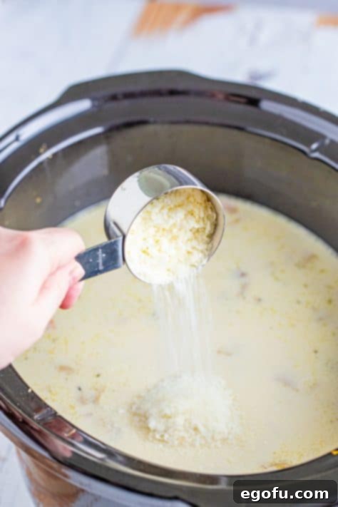 Instant potato flakes being added to a Crockpot soup.