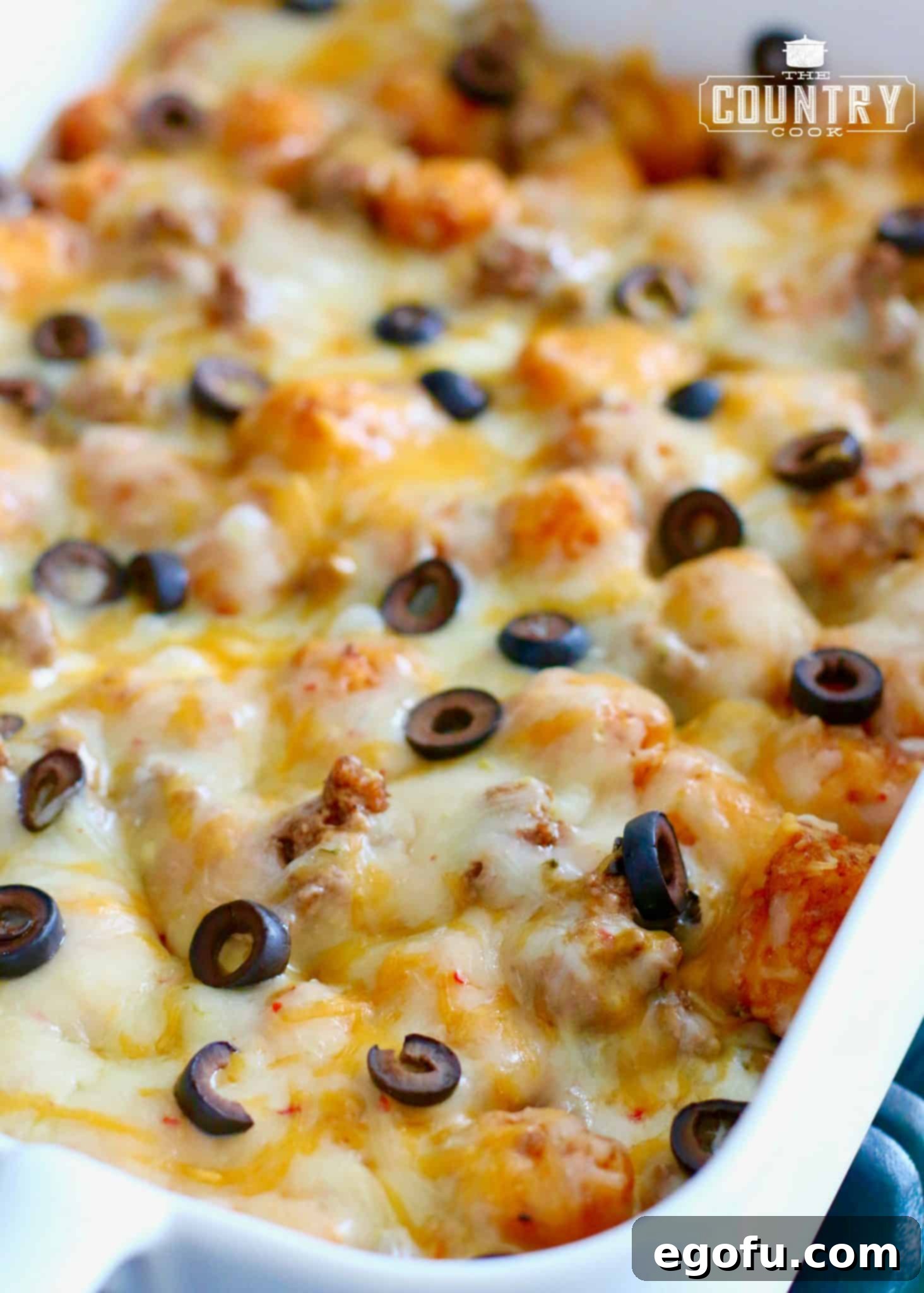 Finished, EASY TATER TOT ENCHILADA BAKE, shown with sliced olives and melted cheese, fresh from the oven.