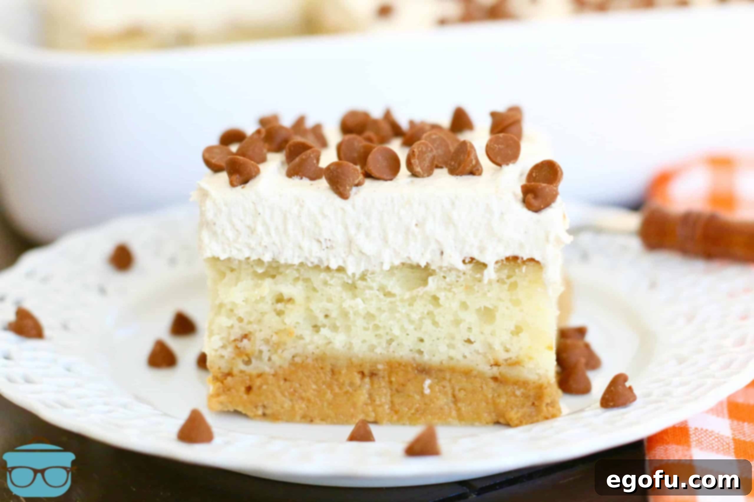 Harvest Moon Pumpkin Dream 2 A perfectly sliced Magic Layer Pumpkin Cake resting on a white plate, garnished with delicate cinnamon chips. The distinct layers of vanilla cake and pumpkin pie filling are visible, showcasing the cake's unique structure.
