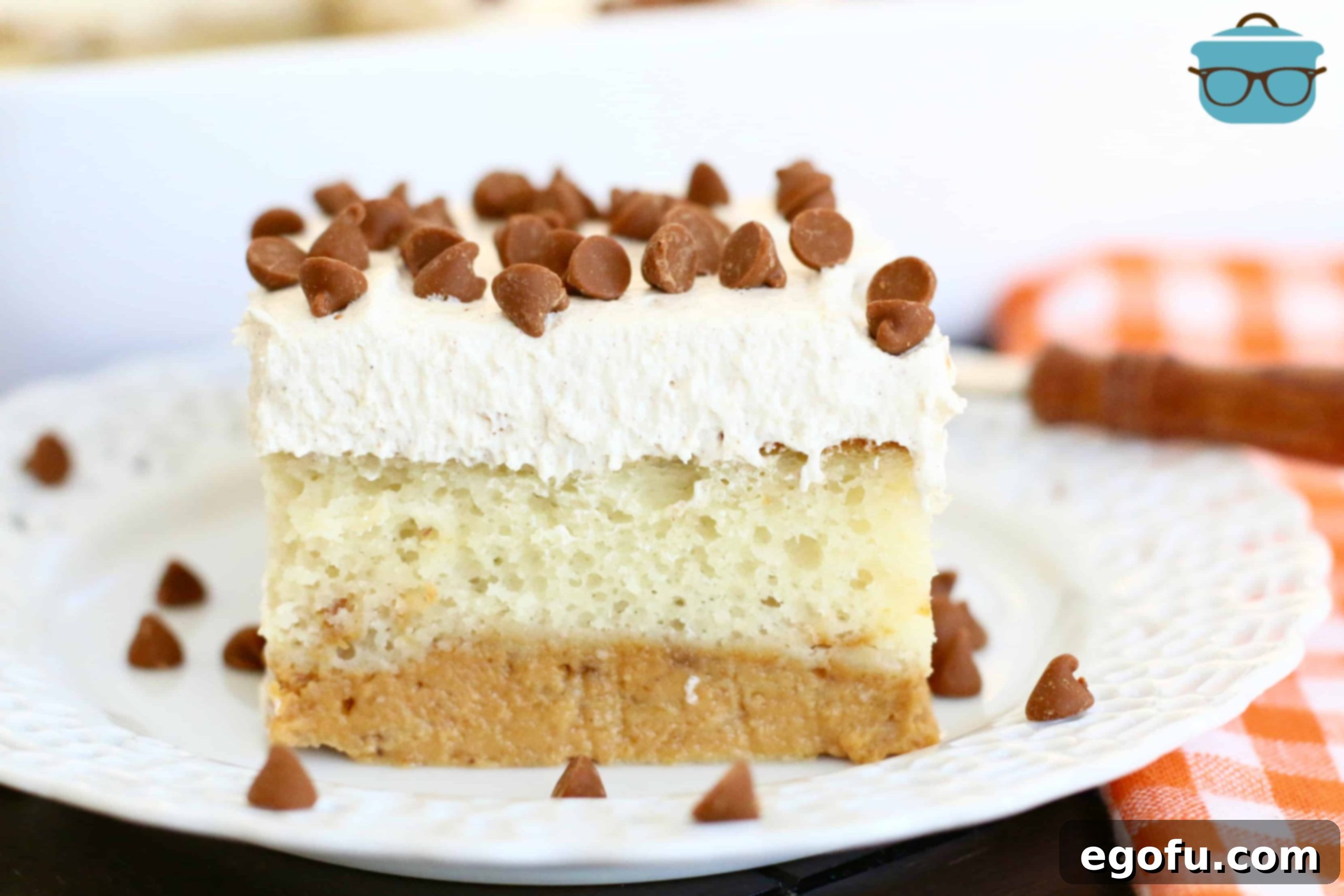 Harvest Moon Pumpkin Dream 18 A tempting slice of Magic Pumpkin Layer Cake, topped with cinnamon chips, presented elegantly on a white plate, showcasing its readiness to be served and enjoyed.