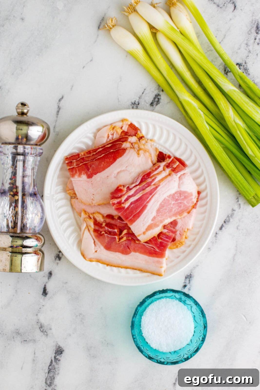 Thick-sliced bacon, cut into uniform thirds, arranged on a white plate.
