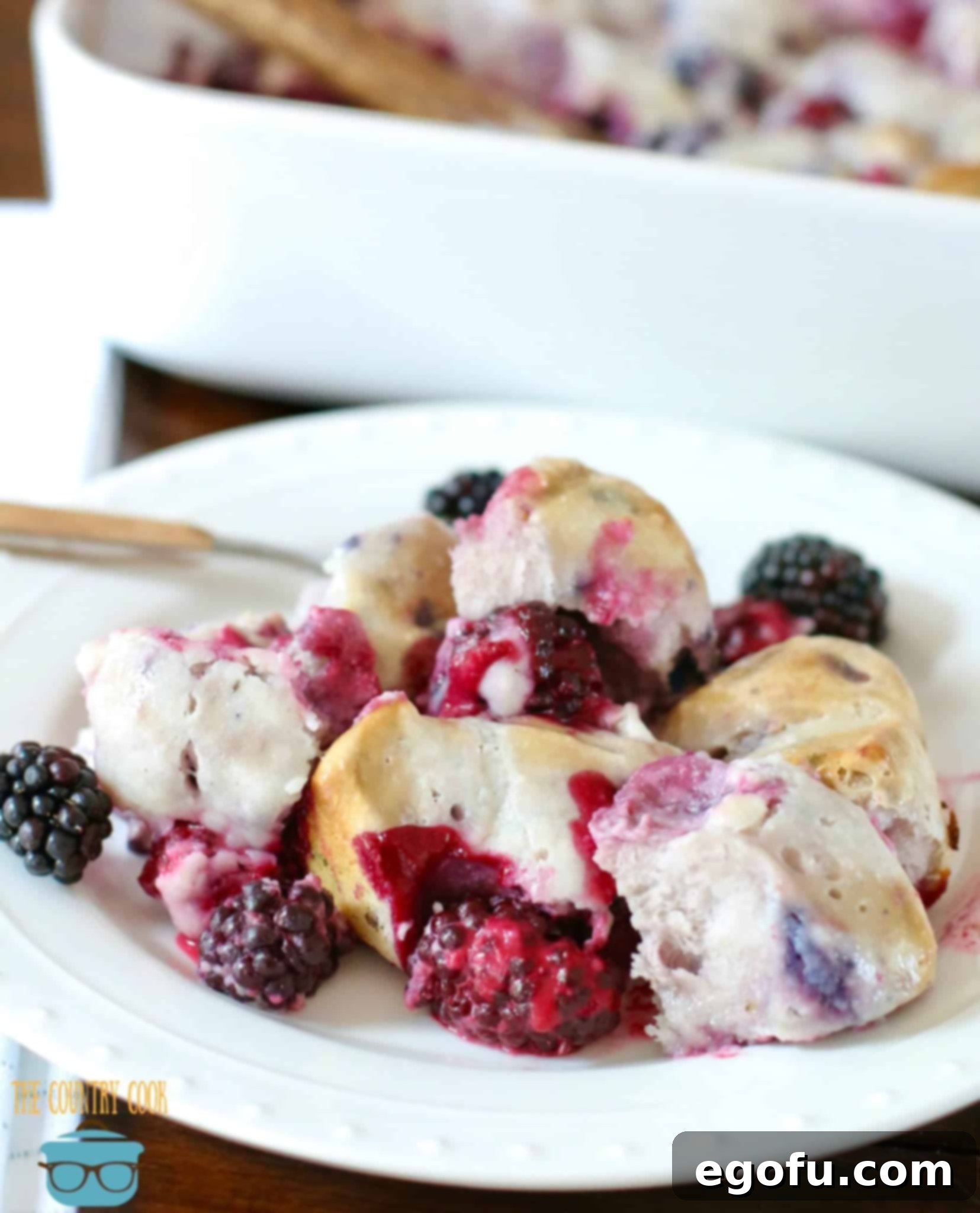 Blackberry Burst Bake 2 Fresh Blackberry Bubble Up shown served on a white round plate. A warm, inviting dessert for any occasion.