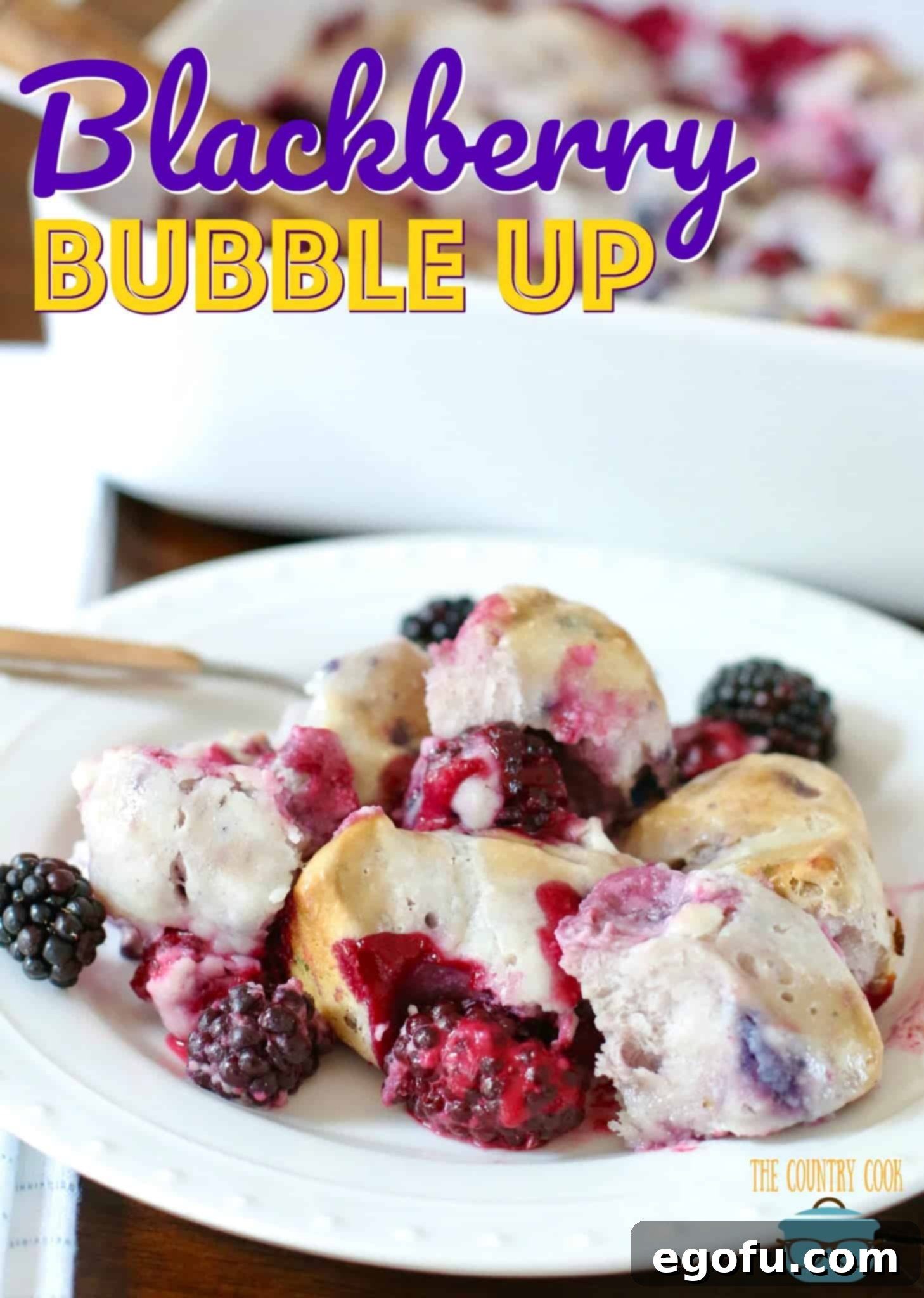 Blackberry Burst Bake 3 A generous serving of Blackberry Bubble Up dessert on a white plate with a fork, ready to be enjoyed.