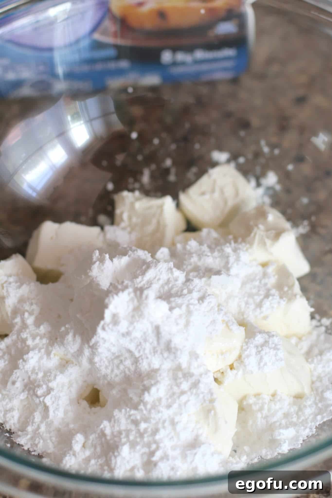 Blackberry Burst Bake 6 Cream cheese and powdered sugar in a clear bowl, ready to be mixed.