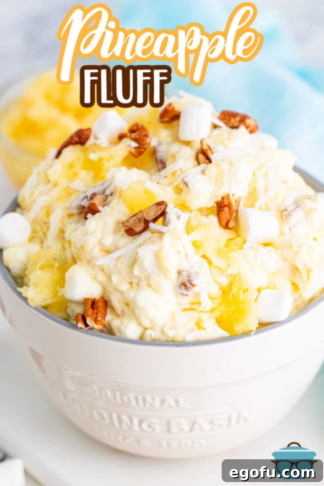 Tropical Cloud Delight 3 A close-up of Pineapple Fluff, perfectly portioned and displayed in a charming small white serving bowl. The image highlights the dessert's creamy texture and the subtle inclusion of pineapple pieces, inviting a taste.