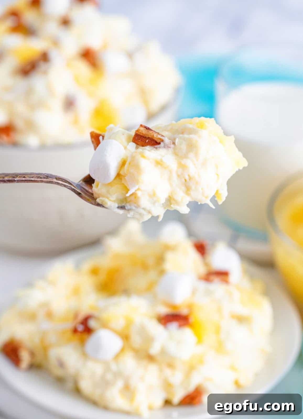 Tropical Cloud Delight 8 A spoon lifting a serving of Pineapple Fluff from a large bowl, demonstrating the perfect consistency of the chilled dessert.