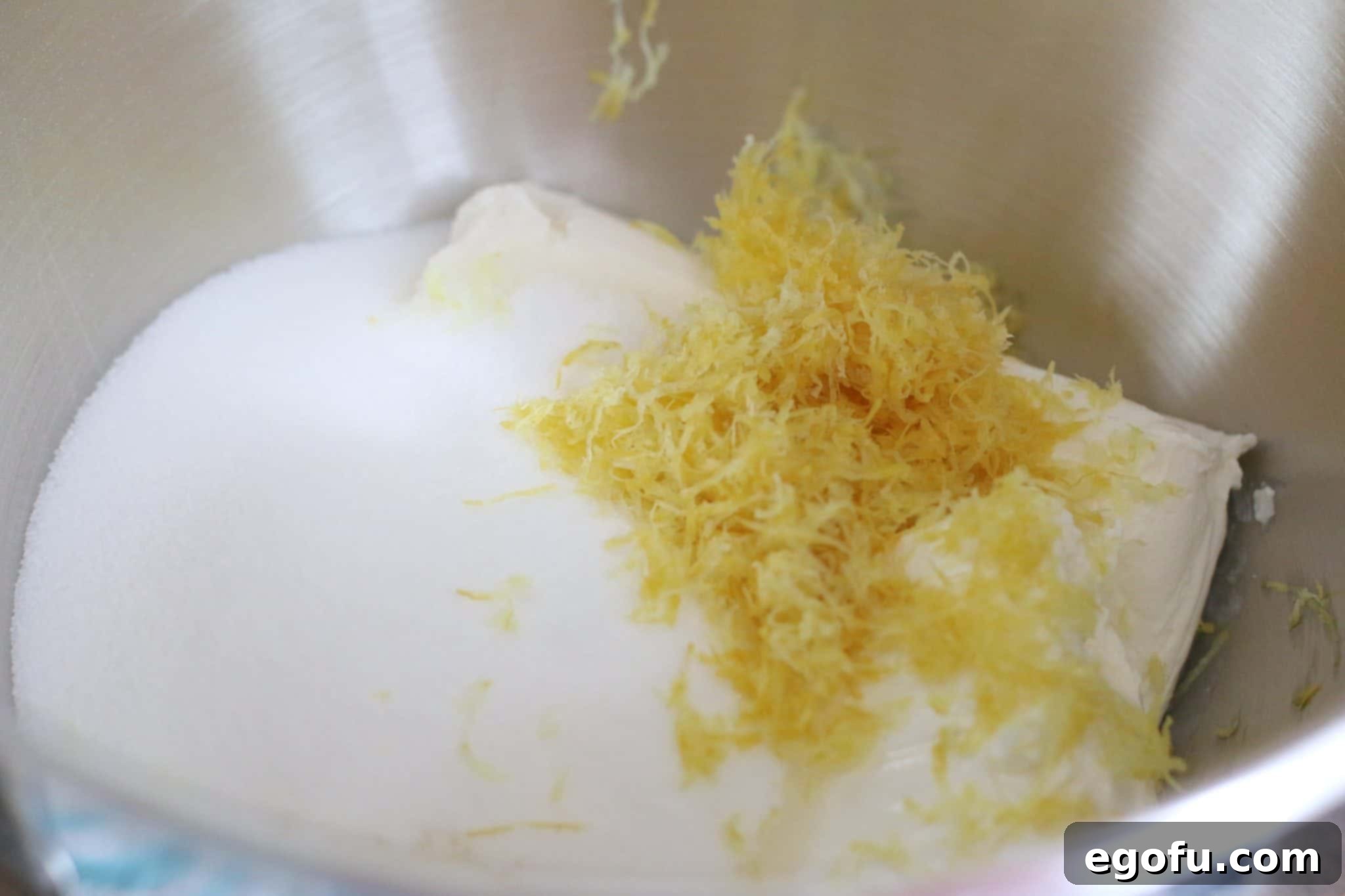Zesty Lemon No-Bake Delight 5 softened cream cheese, sugar, lemon zest in the bottom of a mixing bowl.