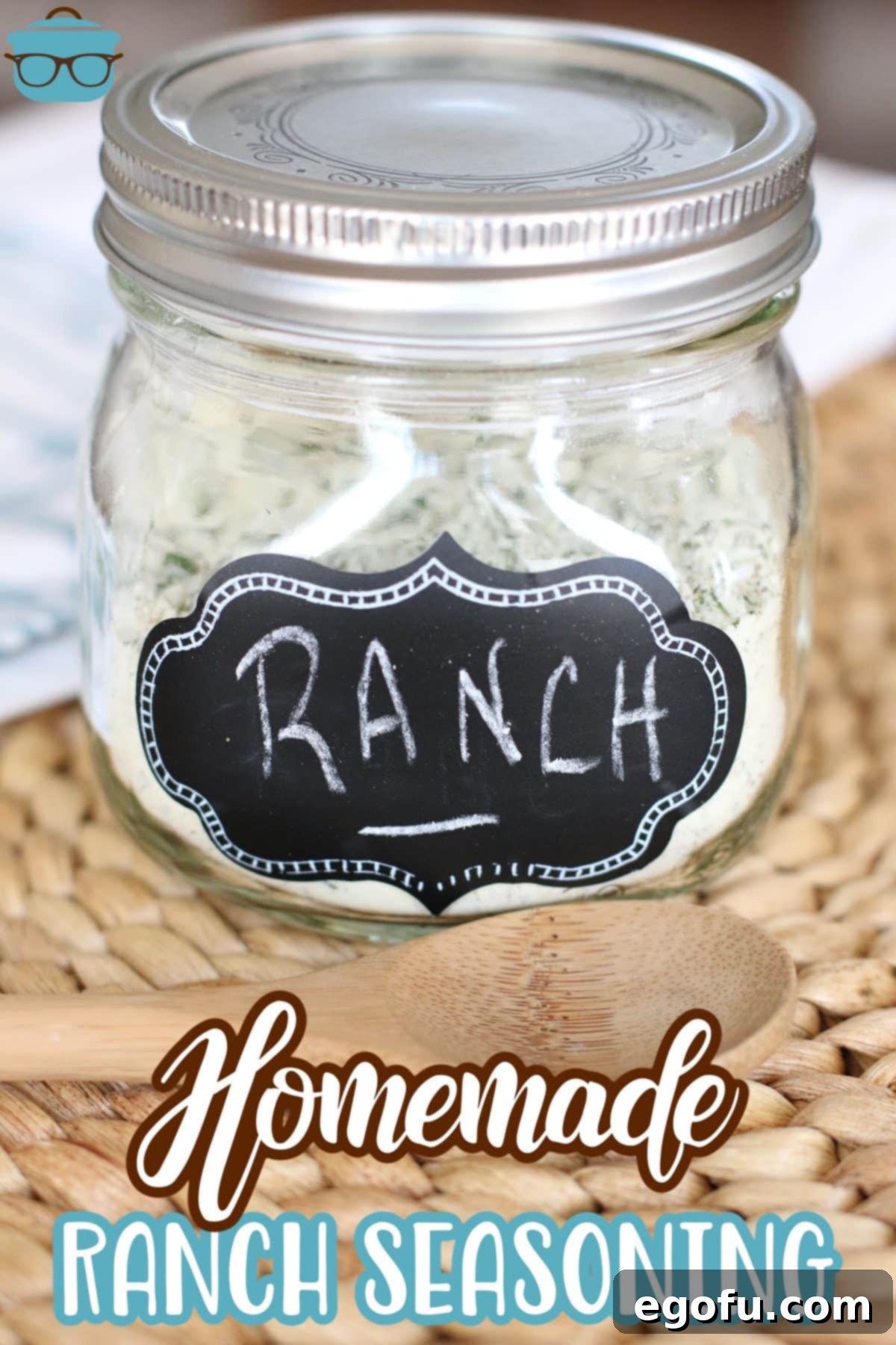 A charming mason jar filled with freshly prepared homemade ranch seasoning mix, accompanied by a small wooden spoon, inviting you to use this delightful blend.