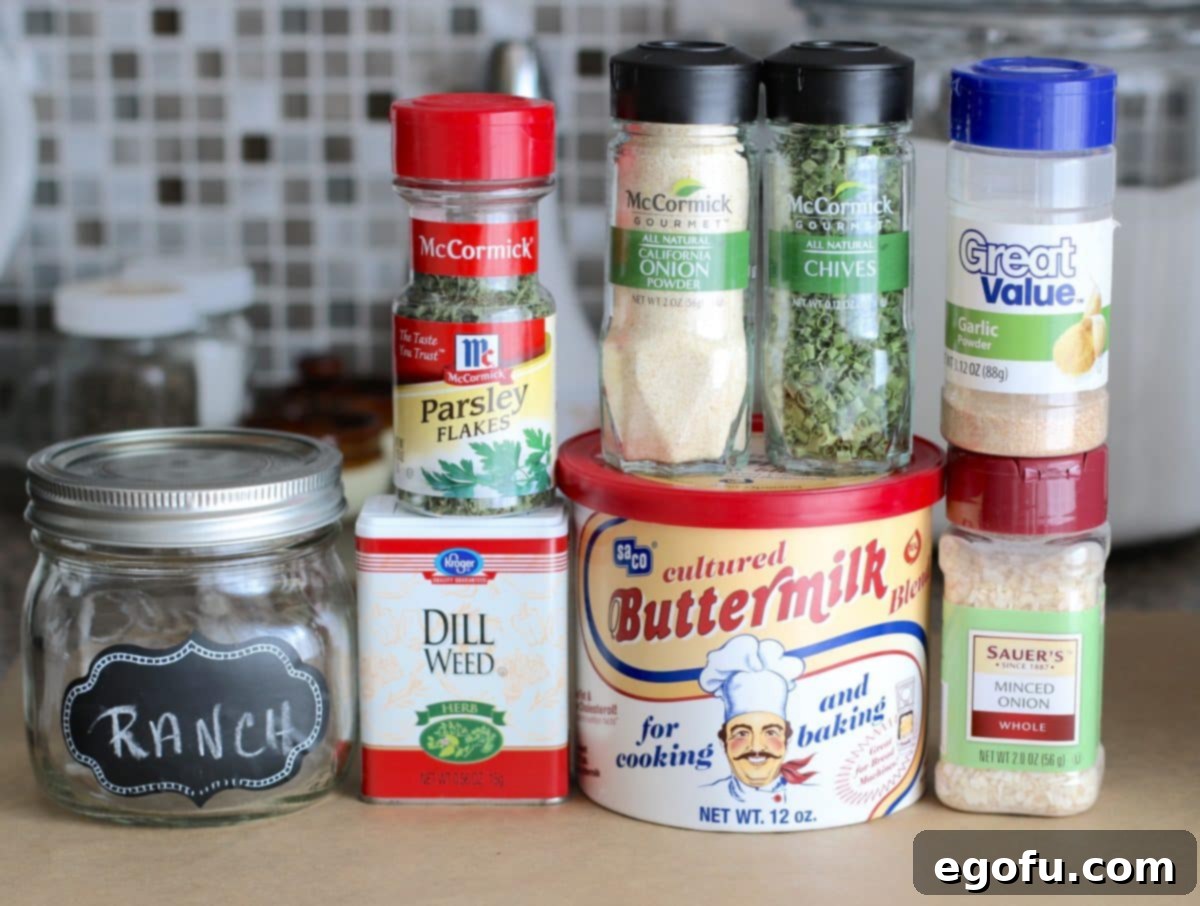 A close-up view of the individual dried ingredients for ranch seasoning: buttermilk powder, minced dried onion, garlic powder, chives, onion powder, parsley flakes, and dill weed, showing their textures and vibrant colors.