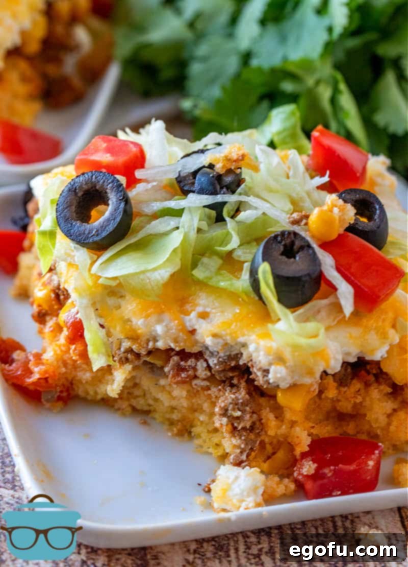 slice of cornbread taco casserole shown on a square white plate