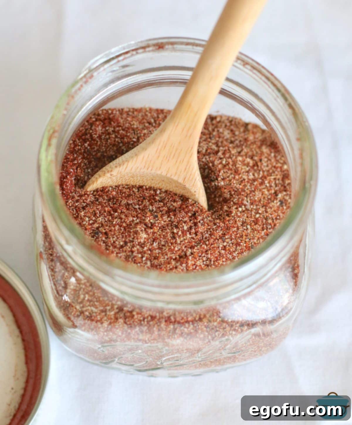 Easy Homemade Taco Seasoning 5 mixing together spices in a mason jar with a small wooden spoon.