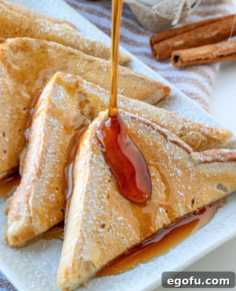 Pillowy French Toast Perfection 2 maple syrup being poured onto a slice of Fluffy French Toast, highlighting its thick, golden texture.