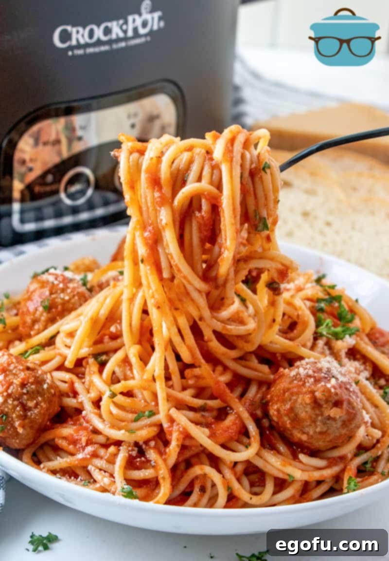 Effortless Slow Cooker Spaghetti and Meatballs 12 A forkful of spaghetti coated with rich spaghetti sauce, lifted from the slow cooker, showcasing the perfectly cooked pasta.