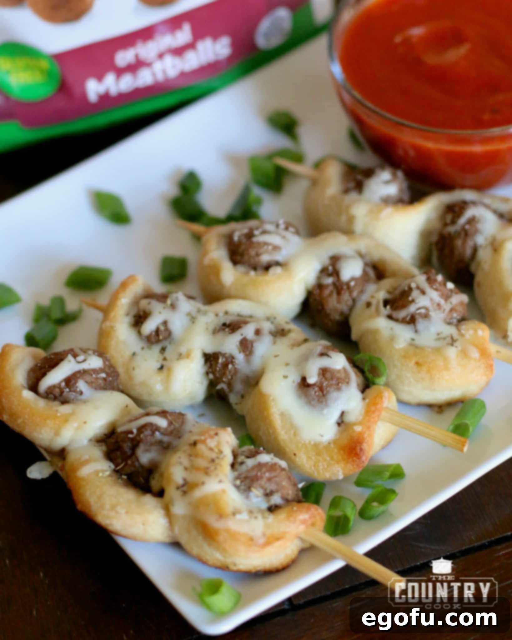 Finished Meatball Subs on a Stick elegantly arranged and served with a bowl of warm marinara dipping sauce.