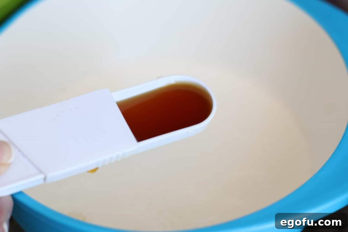vanilla extract added to milk and water in a bowl.