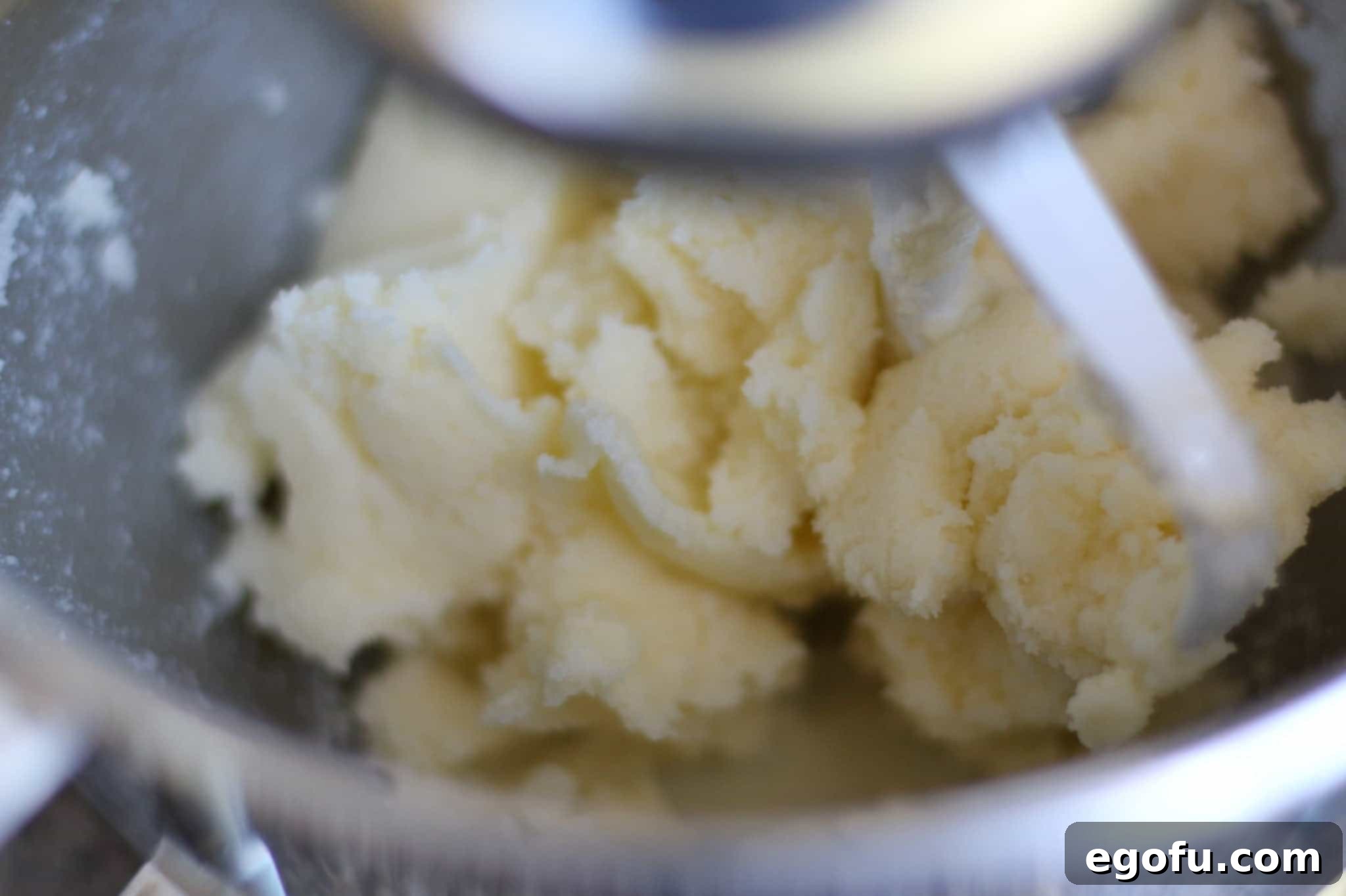 Softened butter and granulated sugar being creamed together in a stand mixer, demonstrating the light and fluffy texture achieved.