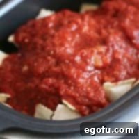 Crock Pot Ravioli in a slow cooker, featuring melted cheese and rich sauce.