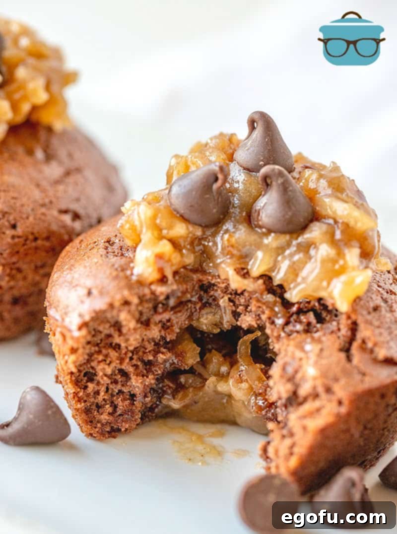 Close up photo of a German Chocolate muffin with a bite removed, showing the rich chocolate cake and creamy coconut pecan filling.