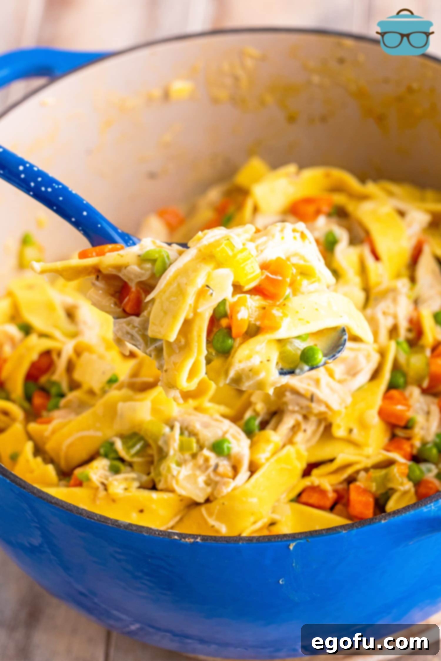 Soul-Warming Chicken and Noodles 8 A close-up shot of a serving spoon holding a generous portion of Hearty Chicken and Noodles directly above the large pot, ready to be served.