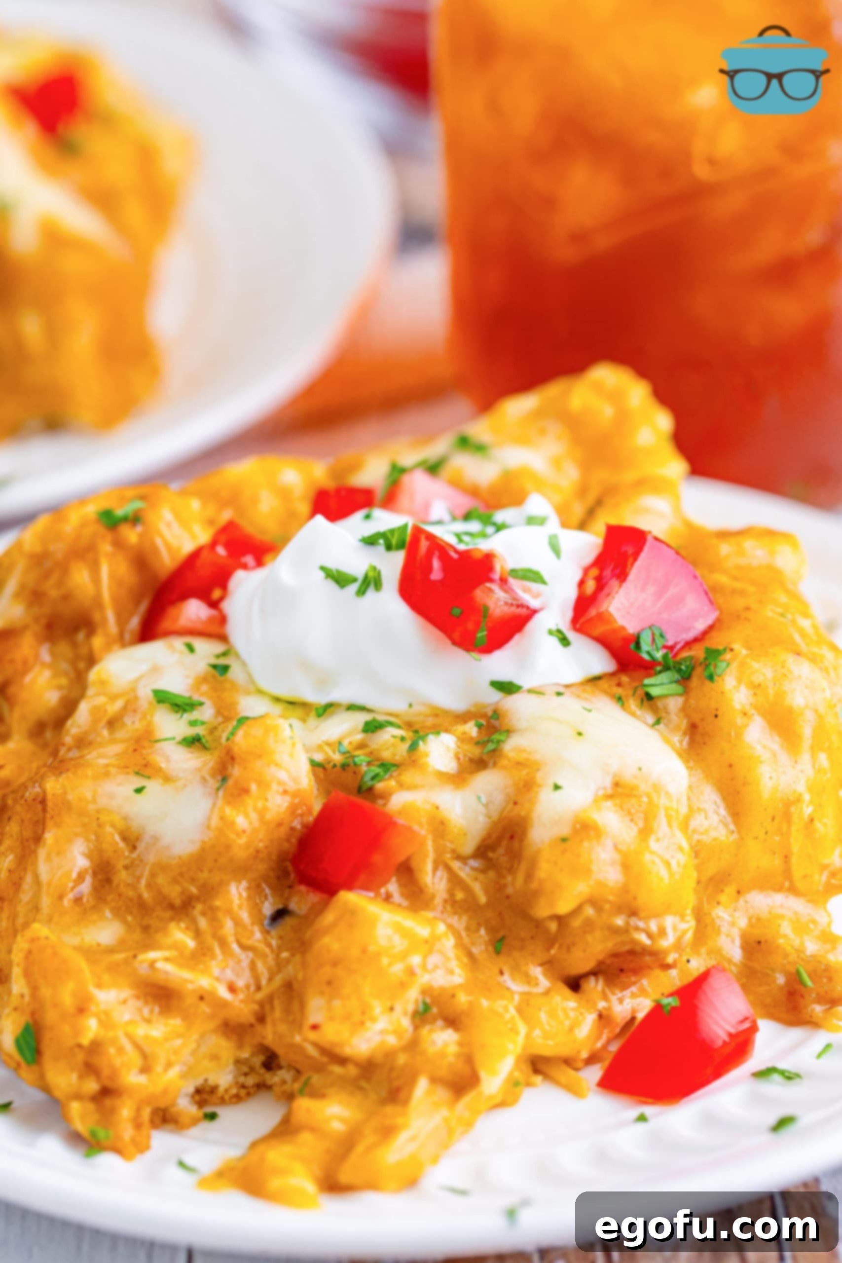 Close-up of a serving of Bisquick Chicken Enchilada Bake on a plate, showcasing its cheesy, saucy layers.