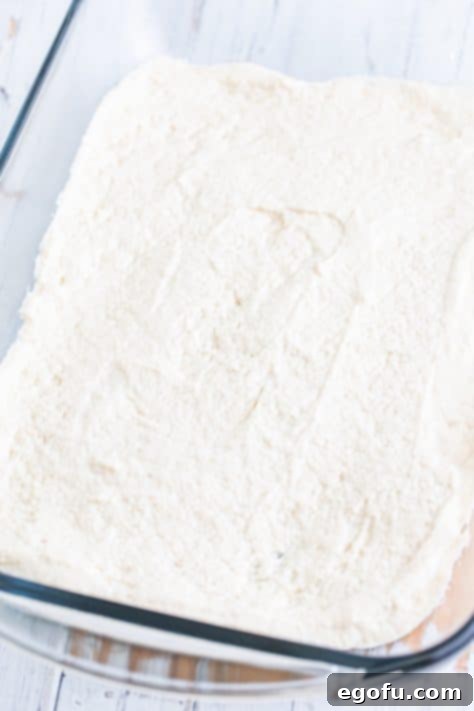 A baking dish with Bisquick mix batter spread out.