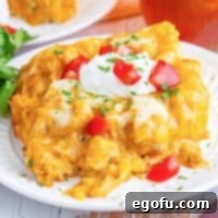 A white plate with a serving of Bisquick Chicken Enchilada Bake, ready to be enjoyed.