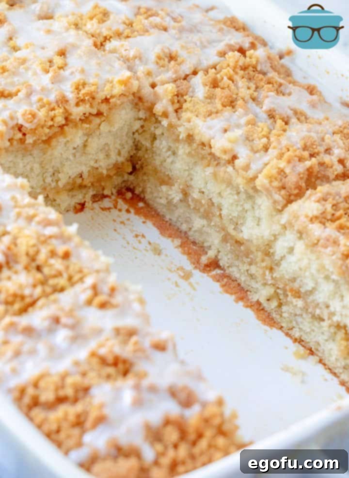 Two slices of the finished Banana Bread Crumb Cake, removed from the baking dish and angled to clearly display the beautiful internal layers of cake and crumb topping.