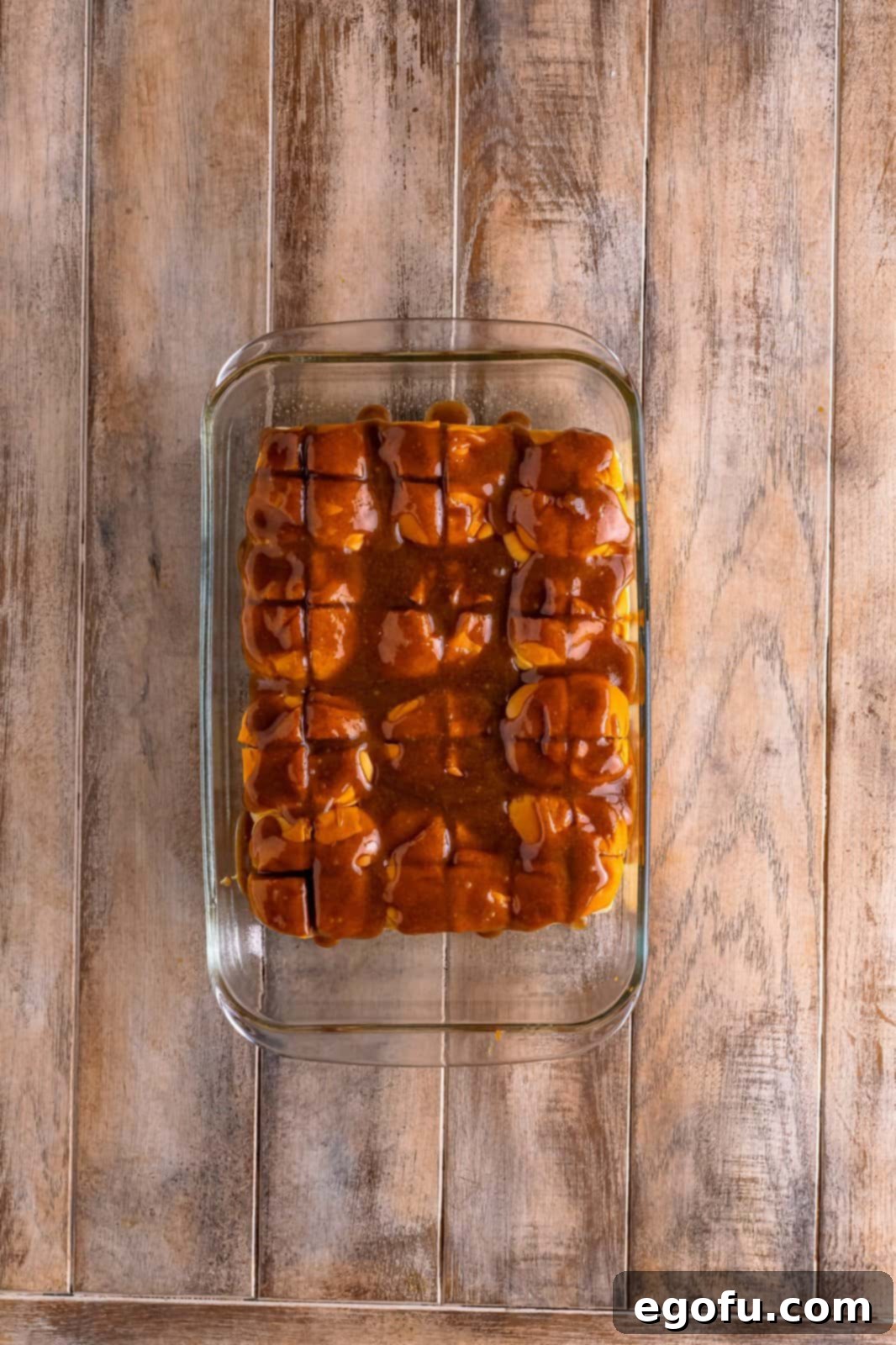 The cinnamon pull-apart bread, fully covered with glaze, placed in the oven for baking.