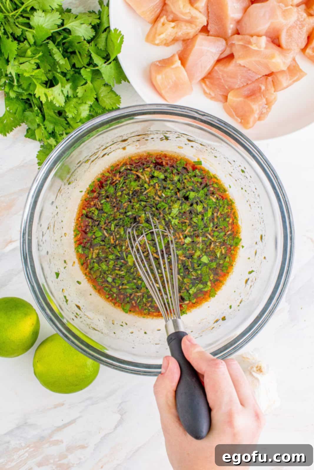 soy sauce, honey, oil, lime juice, Sriracha, garlic and cilantro in a clear glass bowl.