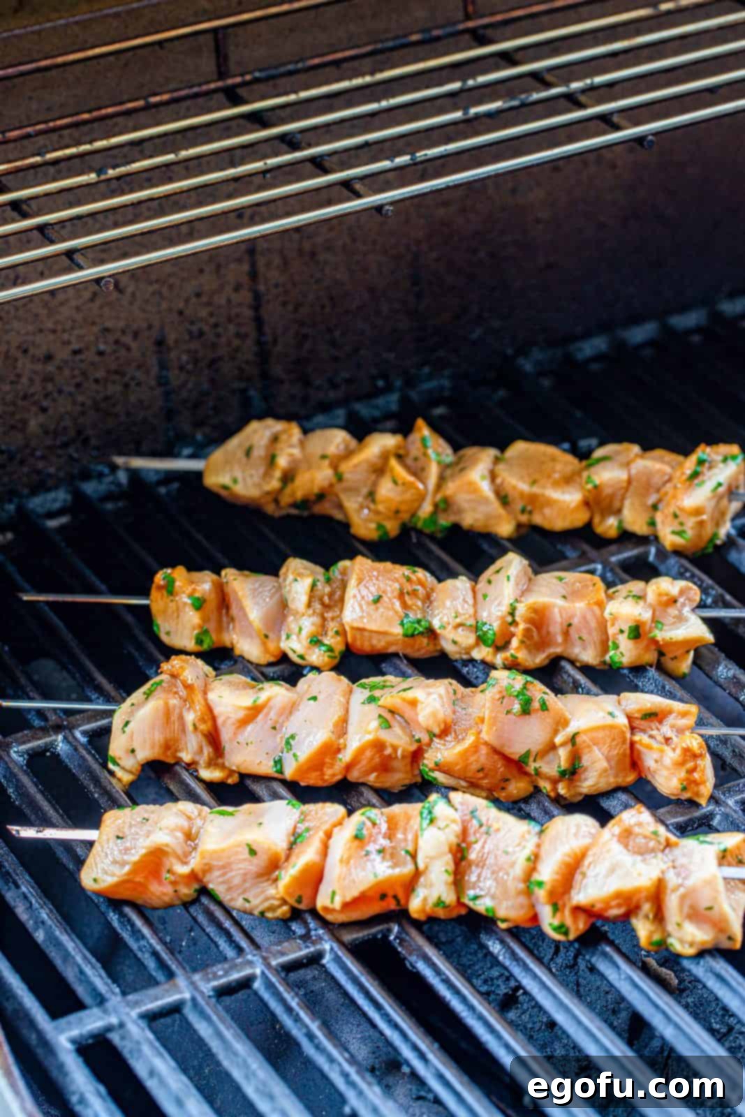 marinated chicken skewers on grill.